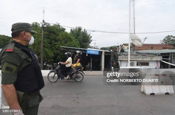 Officers of the Argentine Gendarmerie stand guard at a checkpoint in the border city of Clorinda, across from Nanawa, 50 km of Asuncion, on March 16,...