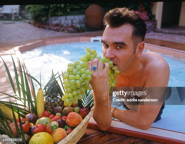 Morrissey, singer, song writer and author enjoys a snack of fruit in his jacuzzi tub in Beverly Hills, California in August 1992. .