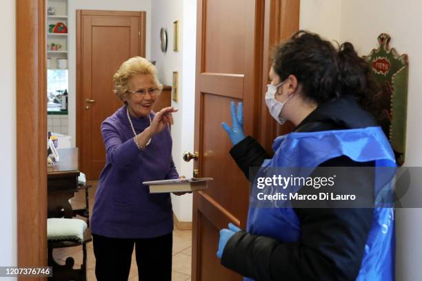 Giulia Baini a volunteer from the Community of Sant'Egidio, speaks to Giovanna, a frail elderly woman of 82 years of age during a home-care service...