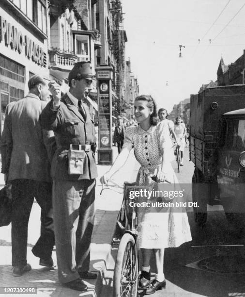 Policeman talking to a young woman with a bicycle on a West Berlin street - Vintage property of ullstein bild