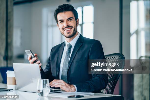handsome businessman sitting in modern office. - young businessman stock pictures, royalty-free photos & images