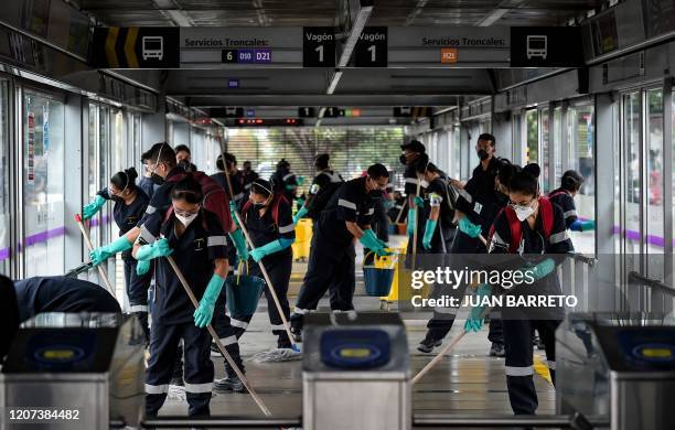 Workers wash and disinfect a bus station, as a measure to prevent the spread of the new Coronavirus, COVID-19, in Bogota on March 16, 2020. The...