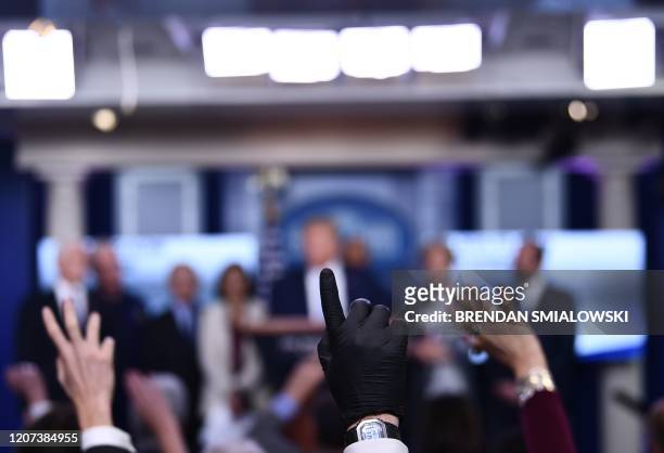 Reporters ask questions as US President Donald Trump speaks during a press briefing at the White House in Washington, DC, on March 16, 2020. - The...