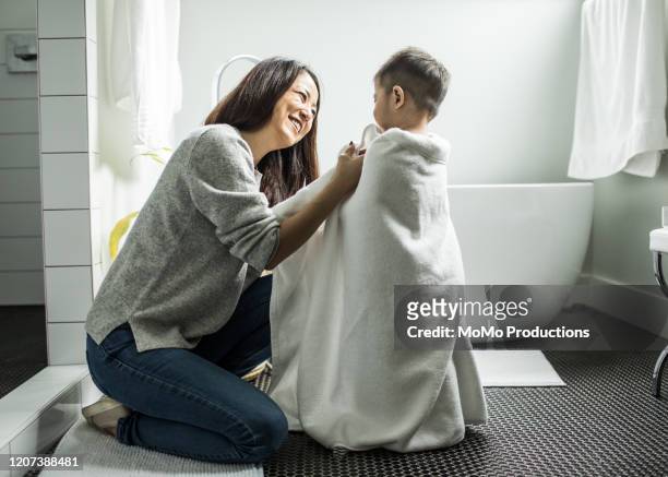 mother bathing young boy (2yrs) in bathroom - brightly lit bathroom stock pictures, royalty-free photos & images