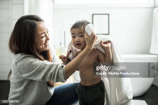 mother bathing young boy (2yrs) in bathroom - kid bath mother stockfoto's en -beelden