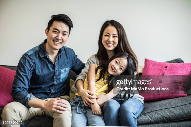 portrait of family at home on couch - östasiatiskt ursprung bildbanksfoton och bilder