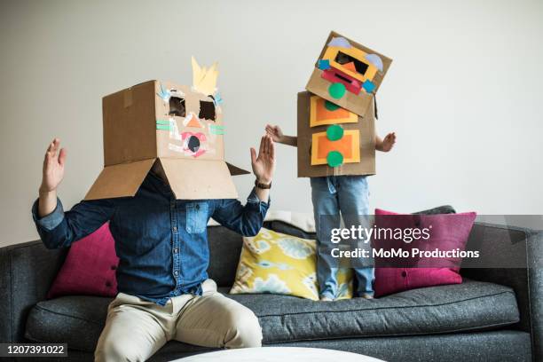 father and daughter wearing robot costumes at home - man sitting on sofa fotografías e imágenes de stock