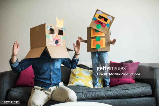 father and daughter wearing robot costumes at home - kinderen spelen stockfoto's en -beelden