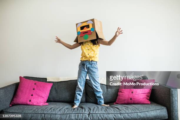 young girl wearing robot costume at home - kreativität stock-fotos und bilder