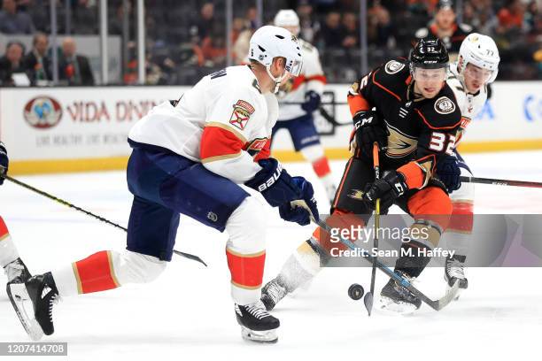 Jacob Larsson of the Anaheim Ducks splits the defense of Frank Vatrano and Anton Stralman of the Florida Panthers during the first period of a game...