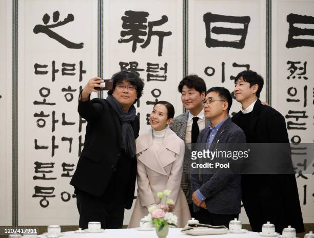 Director Bong Joon-ho takes a selfie with cast members Song Kang-ho, Cho Yeo-jeong and Lee Sun-kyun at the Presidential Blue House on February 20,...