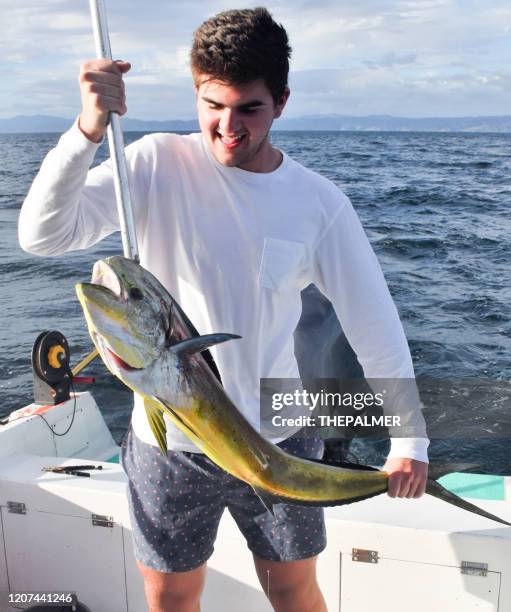 junger fischer fängt einen mahi in costa rica - deep sea fishing stock-fotos und bilder