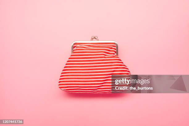 high angle view of red and white striped wallet on pink colored background - rote handtasche stock-fotos und bilder