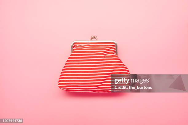high angle view of red and white striped wallet on pink colored background - roze handtas stockfoto's en -beelden