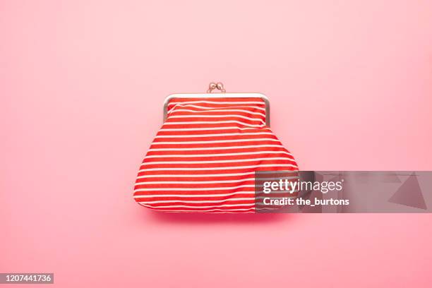 high angle view of red and white striped wallet on pink colored background - white handbag stockfoto's en -beelden