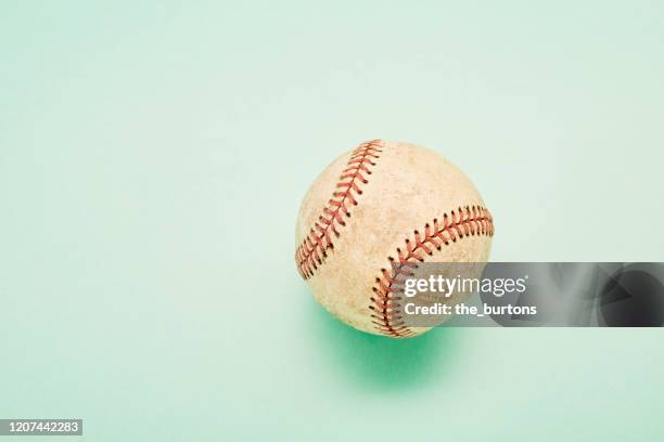 high angle view of an old baseball on turquoise colored background - baseball texture stock pictures, royalty-free photos & images