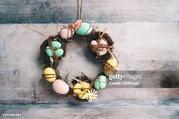 decorated easter eggs wreath on rustic background - easter wreath stock pictures, royalty-free photos & images