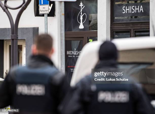 Police officers at the scene outside the Midnight hookah bar, one of two bars that were targeted by a gunman last night, on February 20, 2020 in...