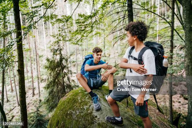 two brothers taking break on rock while out hiking together - big tom stock pictures, royalty-free photos & images