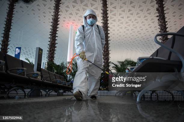 Staff disinfect a seating area at Tianhe airport on 17 march,2020 in Wuhan.Hubei.China. The first batch of medical assistance teams started leaving...