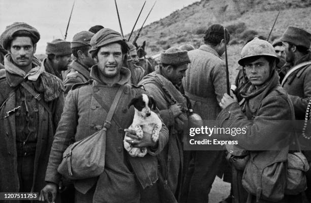 Writer and journalist Ernest Hemingway talks with Republican soldiers before they go into action on the Aragon front during the Spanish Civil War at...