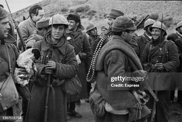 Writer and journalist Ernest Hemingway talks with Republican soldiers before they go into action on the Aragon front during the Spanish Civil War at...