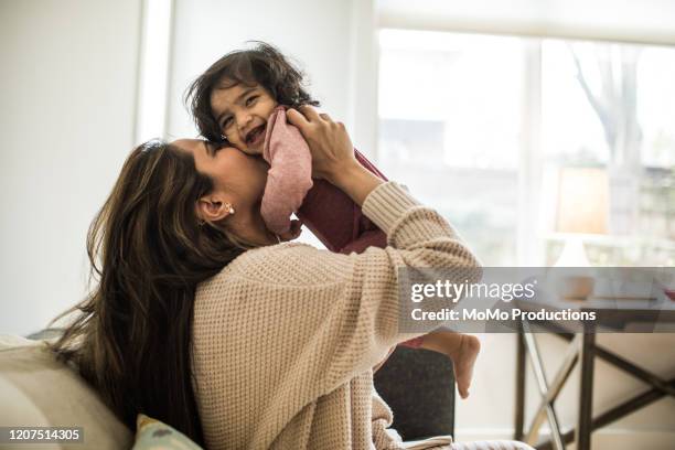 mother playing with infant daughter at home - baby pullover stockfoto's en -beelden