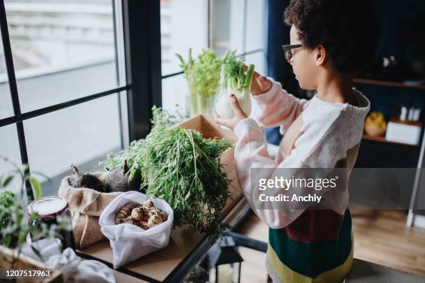 Teenage girl placing groceries to wooden baskets
