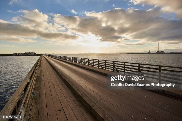 the bridge leading out to dollymount strand and bull island in dublin, ireland - dollymount strand dublin stock pictures, royalty-free photos & images