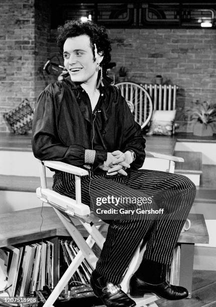 View of English New Wave musician Adam Ant as he sits in a director's chair during an interview at MTV Studios, New York, New York, September 9, 1981.