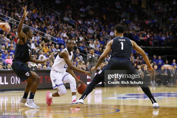 Quincy McKnight of the Seton Hall Pirates in action against Kamar Baldwin and Jordan Tucker of the Butler Bulldogs during a college basketball game...