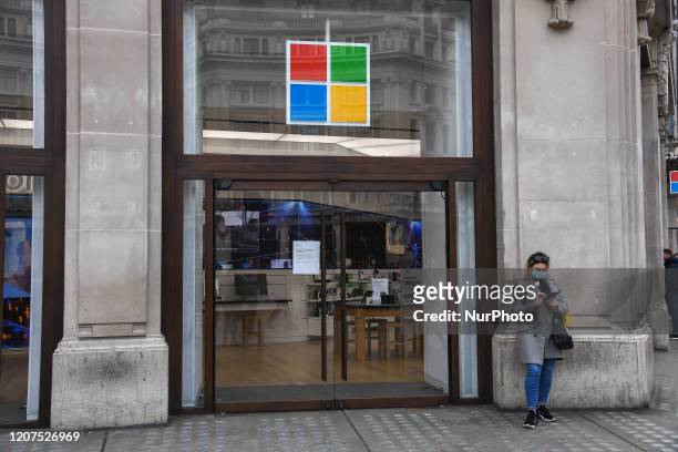 Woman wears a mask as she stands aside a closed Microsoft Store in Oxford Circus on March 17, 2020 in London, England. Boris Johnson held the first...