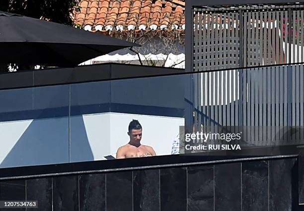 Portugal and Juventus' Portuguese forward Cristiano Ronaldo sunbathes at his home in Funchal on March 16, 2020. - Ronaldo has been in quarantine in...