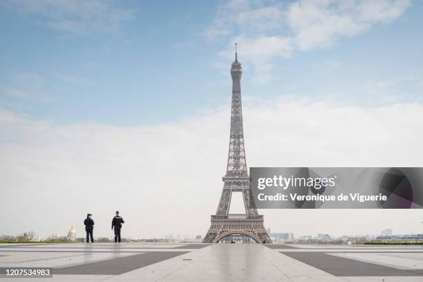 Police officers patrol near the Eiffel Tower during a government enforced quarantine on March 17, 2020 in Paris, France. On March 17, 2020 France...