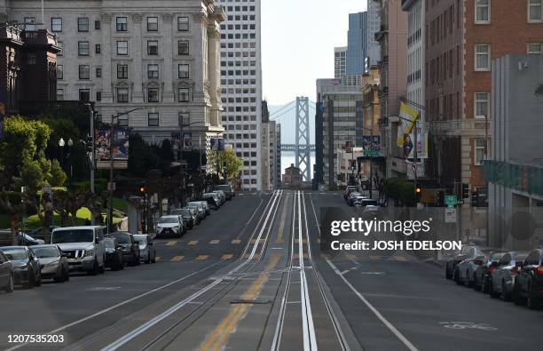 California Street, usually filled with iconic cable cars, is seen mostly empty in San Francisco, California on March 17, 2020. - Millions of San...