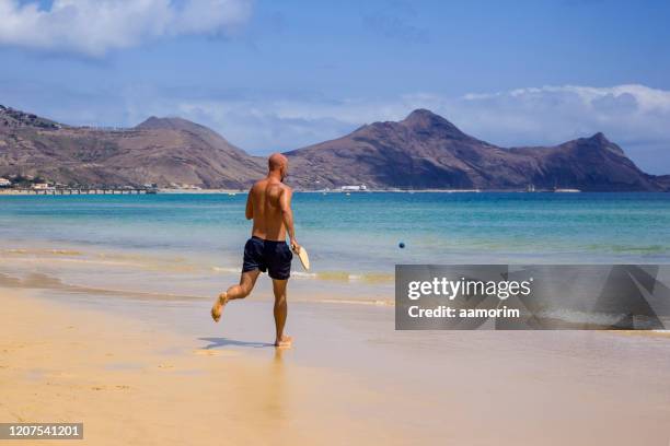 man playing racketball at the beach in porto santo - racketball stock pictures, royalty-free photos & images