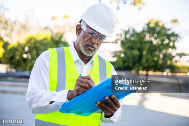 inspeção do gerente de construção do homem negro sênior - controle de qualidade - fotografias e filmes do acervo