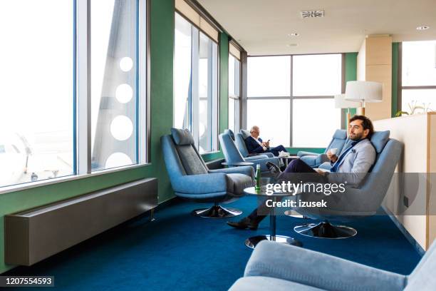 gente de negocios esperando vuelo en la sala vip del aeropuerto - sala de espera característica de edificio fotografías e imágenes de stock