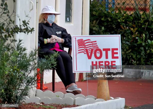 Poll worker at the First Baptist Church voting site in Hollywood, Fla. Wears a protective mask and gloves on Tuesday, March 17, 2020. Voting in...