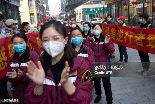 This photo taken on March 17, 2020 shows medical workers from Guizhou province being celebrated in a ceremony as they depart from Wuhan, in China's...