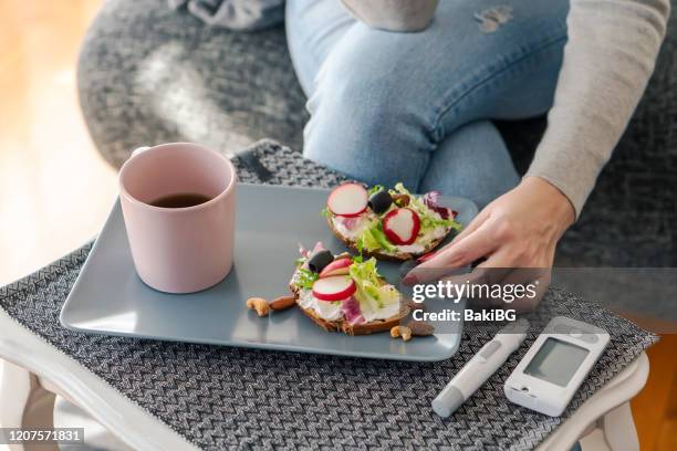 jonge diabetische vrouw die ontbijt thuis heeft - glucose stockfoto's en -beelden