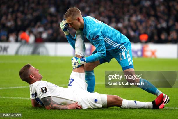 Karl-Johan Johnsson of FC Kobenhavn helps Mohamed Elyounoussi of Celtic with cramp during the UEFA Europa League round of 32 first leg match between...