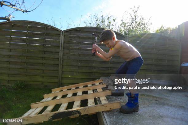 boy using hammer to break wood - demolition film 2015 stock-fotos und bilder