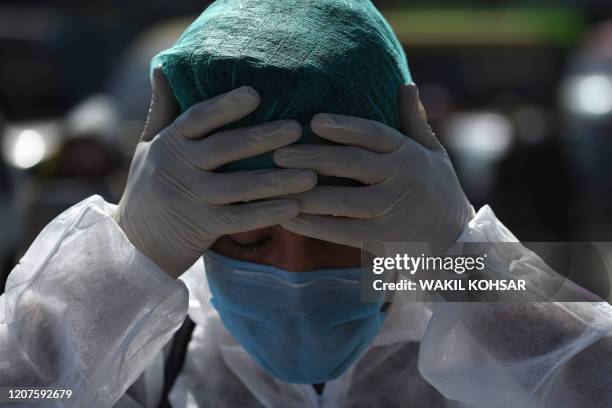 Volunteer wearing a hazmat suit and a facemask prepares before the start of a preventive campaign against the spread of the COVID-19 coronavirus, in...
