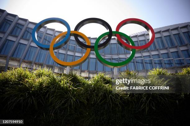 The Olympic Rings logo is pictured in front of the headquarters of the International Olympic Committee in Lausanne on March 18 as doubts increase...