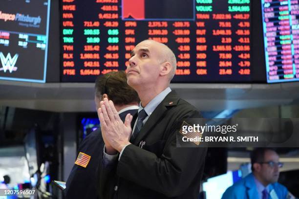 Traders work on the floor at the opening bell of the Dow Industrial Average at the New York Stock Exchange on March 18, 2020 in New York. - Wall...