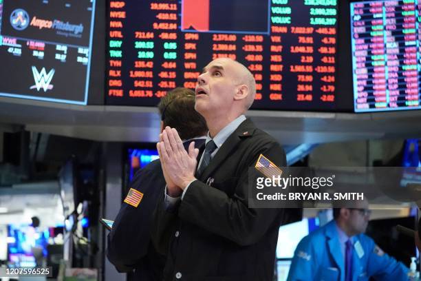 Traders work on the floor at the opening bell of the Dow Industrial Average at the New York Stock Exchange on March 18, 2020 in New York. - Wall...