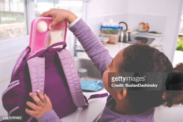 girl packing lunch box for school / kindergarten. - open rucksack stock pictures, royalty-free photos & images