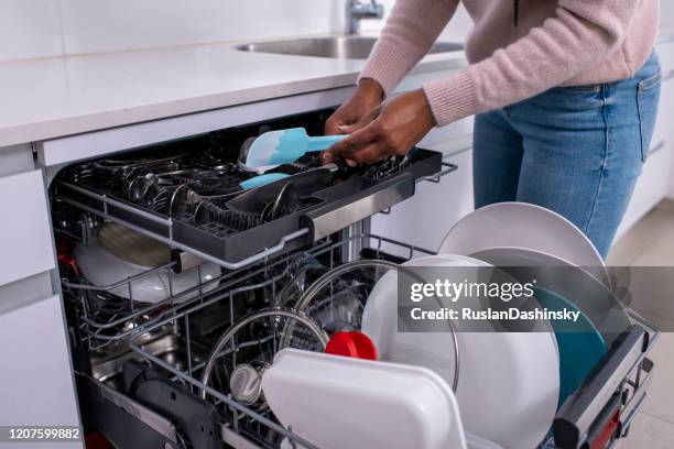 woman unloading dishwasher after washing. - turner contemporary stock pictures, royalty-free photos & images