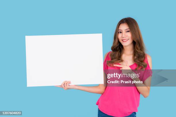 banner of young happy asian woman feeling happiness and holding empty white canvas frame for text or advertising isolated on cyan background - folleto papel blanco fotografías e imágenes de stock